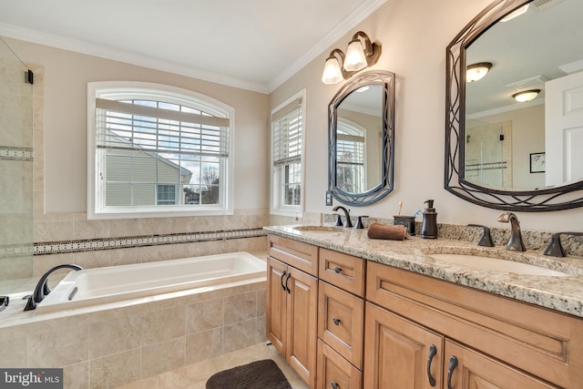 bathroom with tile patterned flooring, vanity, crown molding, and tiled tub