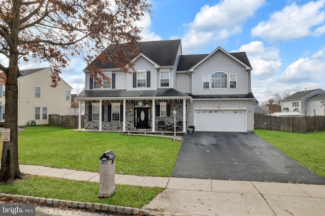 front of property featuring a front lawn, covered porch, and a garage