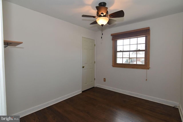 spare room with ceiling fan and dark wood-type flooring