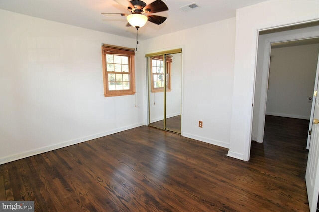 unfurnished bedroom featuring dark hardwood / wood-style flooring, a closet, and ceiling fan