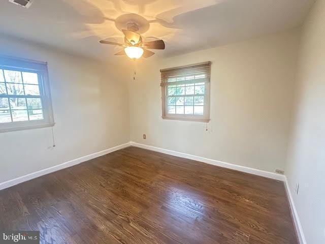 unfurnished room with ceiling fan and dark hardwood / wood-style flooring