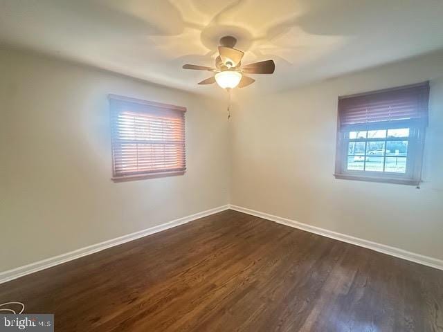 unfurnished room with plenty of natural light, ceiling fan, and dark hardwood / wood-style flooring