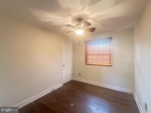 spare room with ceiling fan and dark hardwood / wood-style flooring