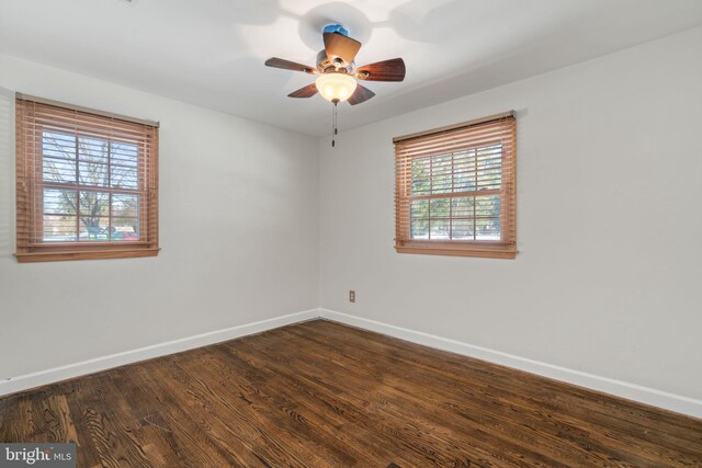 unfurnished room with ceiling fan and dark wood-type flooring