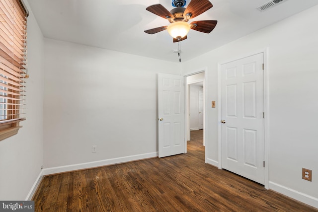 unfurnished bedroom featuring ceiling fan and dark hardwood / wood-style flooring