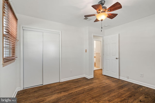 unfurnished bedroom featuring dark hardwood / wood-style flooring, ceiling fan, and a closet