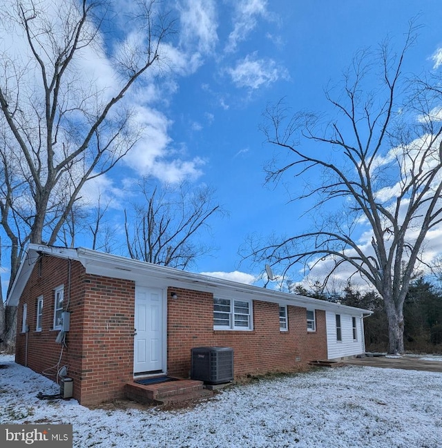 snow covered property featuring central AC unit