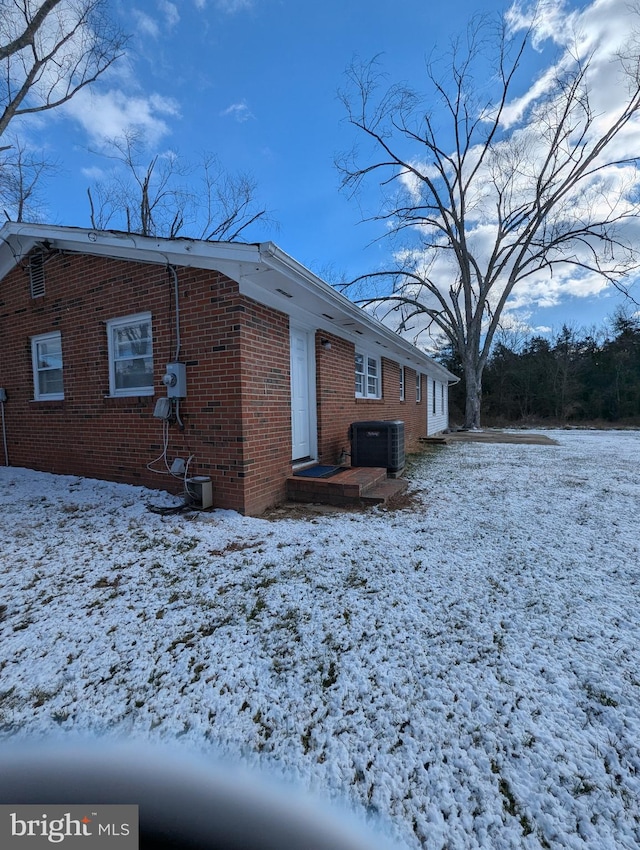 snow covered property featuring central AC