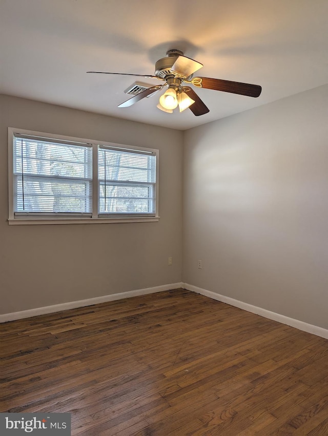 empty room with ceiling fan and dark hardwood / wood-style flooring