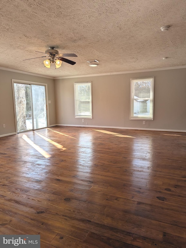 empty room with ceiling fan, ornamental molding, dark hardwood / wood-style flooring, and a textured ceiling