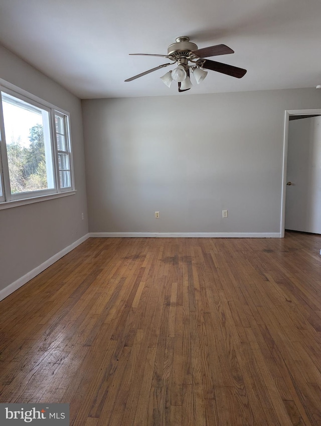 spare room featuring dark hardwood / wood-style flooring and ceiling fan