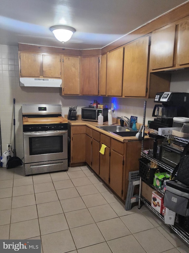 kitchen featuring appliances with stainless steel finishes, light tile patterned floors, and sink