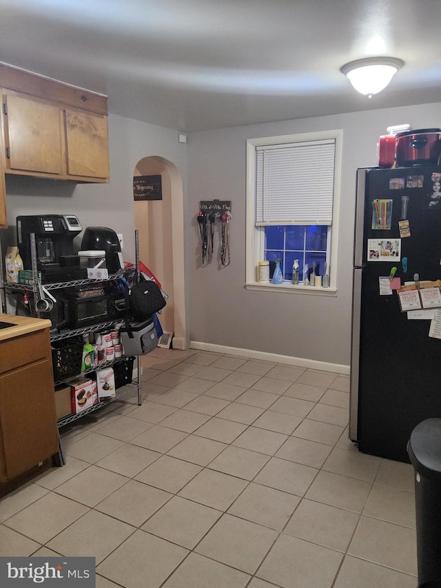 kitchen with stainless steel fridge and light tile patterned floors