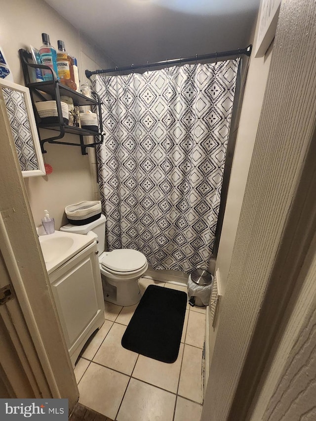 bathroom with toilet, a shower with curtain, vanity, and tile patterned floors