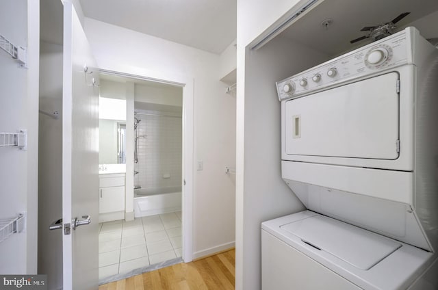 laundry area featuring stacked washing maching and dryer and light tile patterned flooring