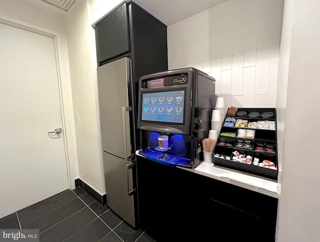 kitchen featuring stainless steel fridge and dark tile patterned flooring