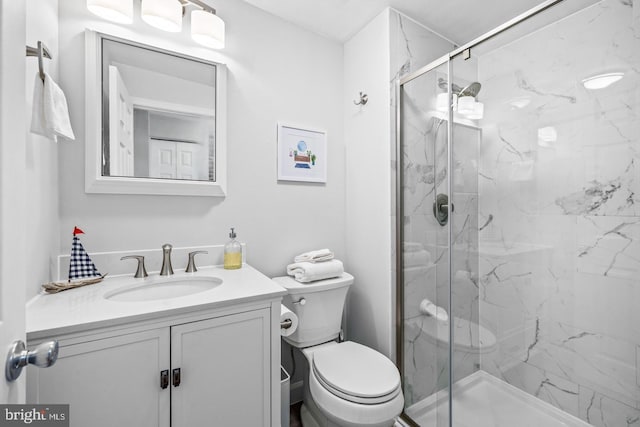 bathroom with vanity, toilet, and a shower with shower door