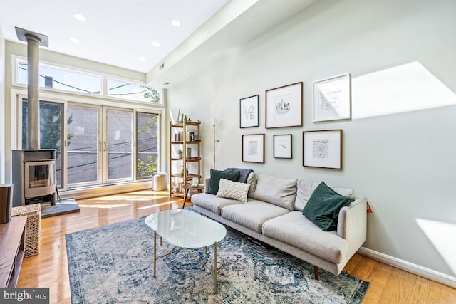 living room with light hardwood / wood-style floors and a wood stove