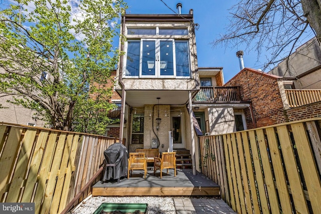 back of property featuring a wooden deck and a balcony