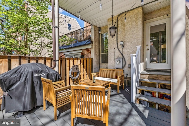 wooden terrace with an outdoor living space