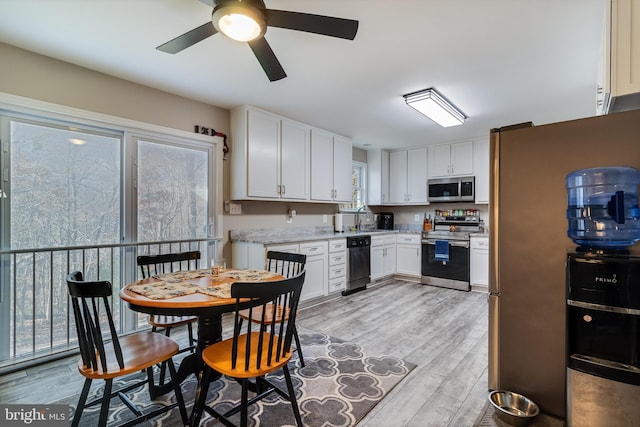 kitchen with white cabinetry, light hardwood / wood-style flooring, ceiling fan, and appliances with stainless steel finishes