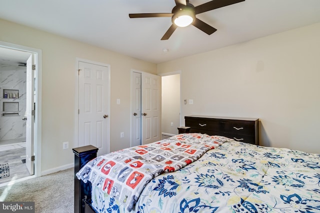 carpeted bedroom with ensuite bathroom and ceiling fan