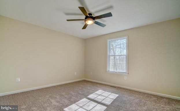 unfurnished room featuring light colored carpet and ceiling fan