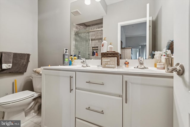 bathroom featuring vanity, a shower with shower door, and toilet