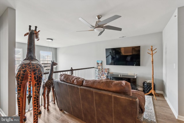 living room featuring light hardwood / wood-style floors and ceiling fan