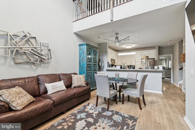 living room featuring light hardwood / wood-style flooring and ceiling fan