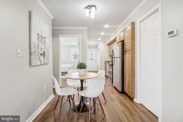 dining room featuring ornamental molding and light wood-type flooring