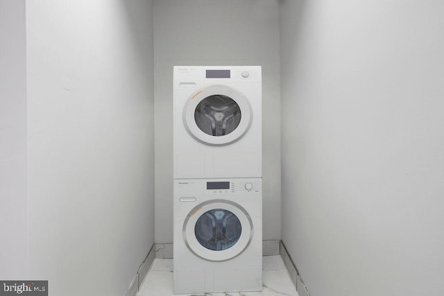 clothes washing area featuring stacked washer / dryer