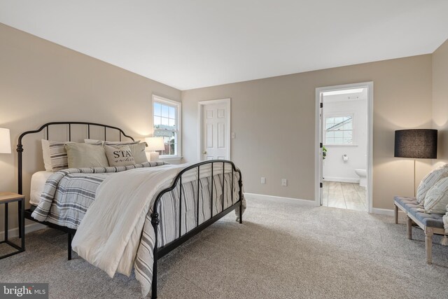 carpeted bedroom featuring ensuite bath