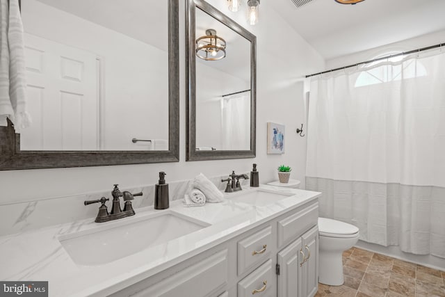 bathroom with vanity, curtained shower, and toilet