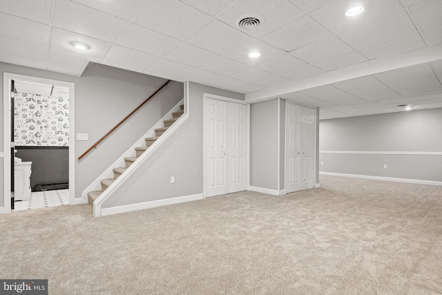 basement with carpet and a paneled ceiling