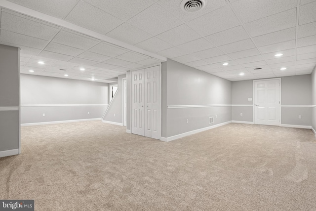 basement featuring carpet flooring and a paneled ceiling