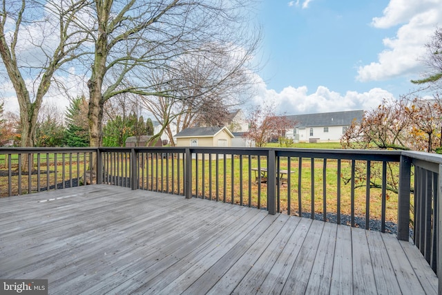 wooden terrace featuring a lawn