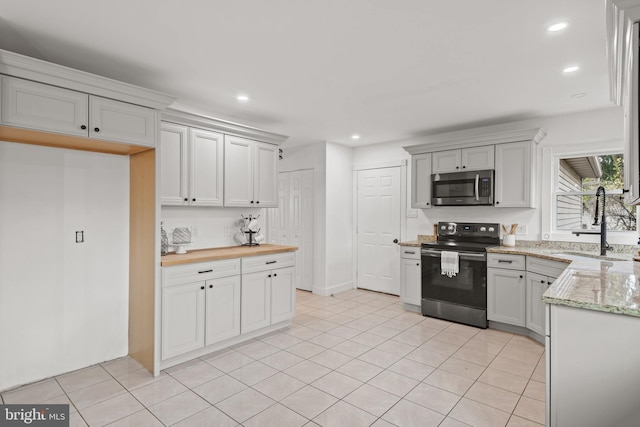 kitchen featuring butcher block counters, sink, white cabinets, and appliances with stainless steel finishes