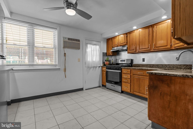 kitchen featuring a wealth of natural light, stainless steel gas stove, ceiling fan, and sink