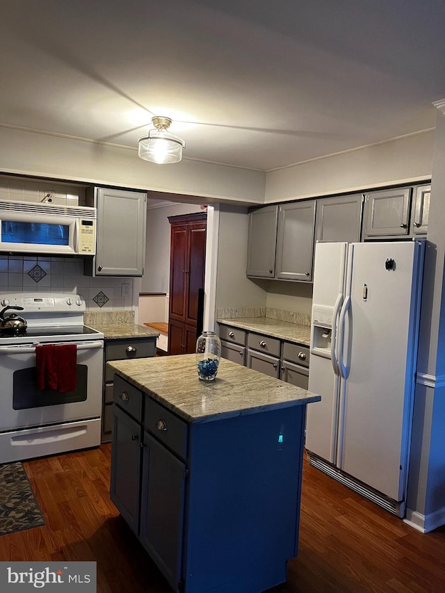 kitchen featuring backsplash, gray cabinetry, white appliances, dark wood-type flooring, and a kitchen island