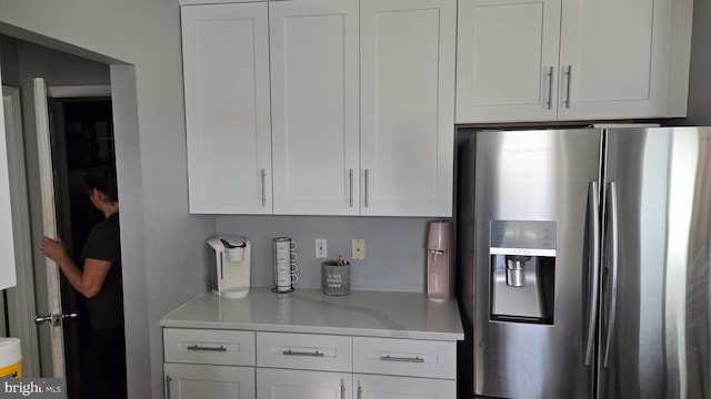 kitchen with stainless steel refrigerator with ice dispenser and white cabinetry