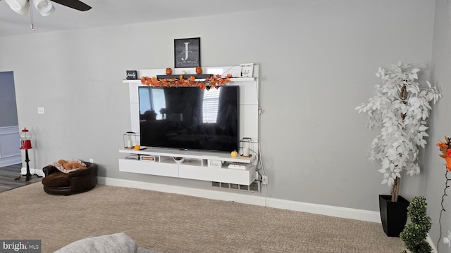 carpeted living room with ceiling fan