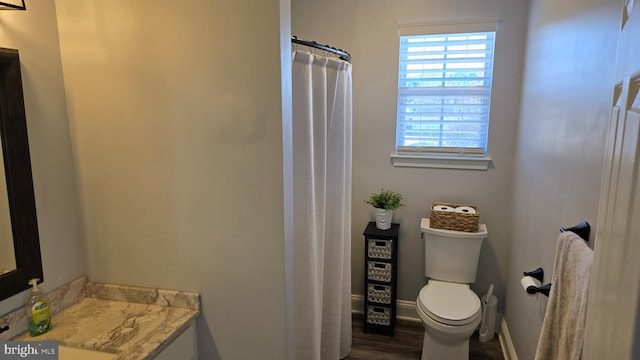 bathroom with vanity, toilet, and wood-type flooring