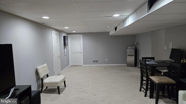 dining room featuring light colored carpet and a drop ceiling