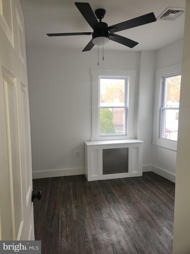 spare room with dark hardwood / wood-style floors and ceiling fan