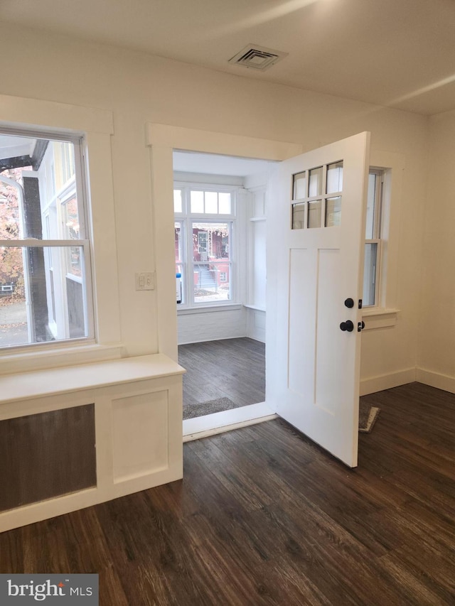 foyer entrance featuring dark wood-type flooring and radiator