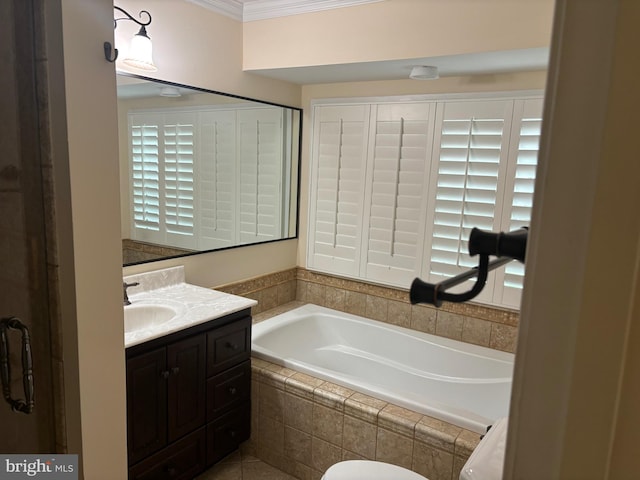 bathroom featuring tile patterned floors, vanity, crown molding, and tiled tub