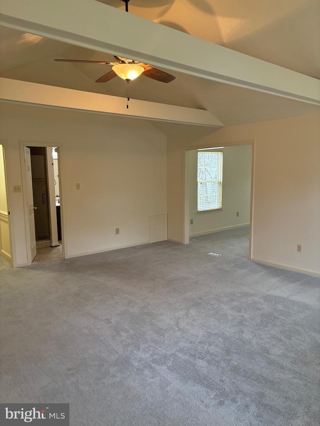 carpeted empty room featuring vaulted ceiling with beams and ceiling fan