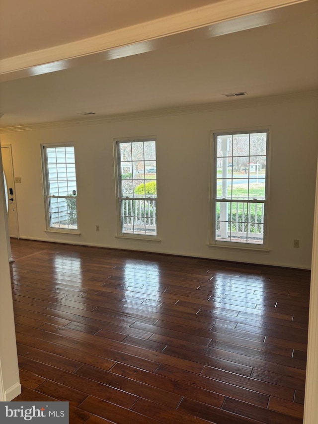 empty room with crown molding and dark wood-type flooring