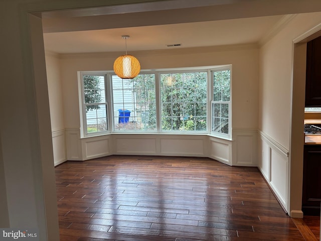 unfurnished dining area featuring dark wood-type flooring and ornamental molding